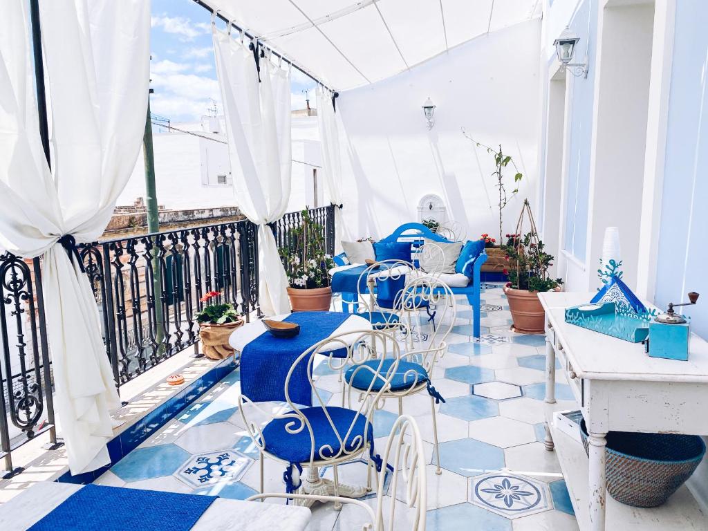 um pátio com cadeiras e mesas azuis numa varanda em La Casa Di Ada E Gigi Vacanze em Porto Cesareo