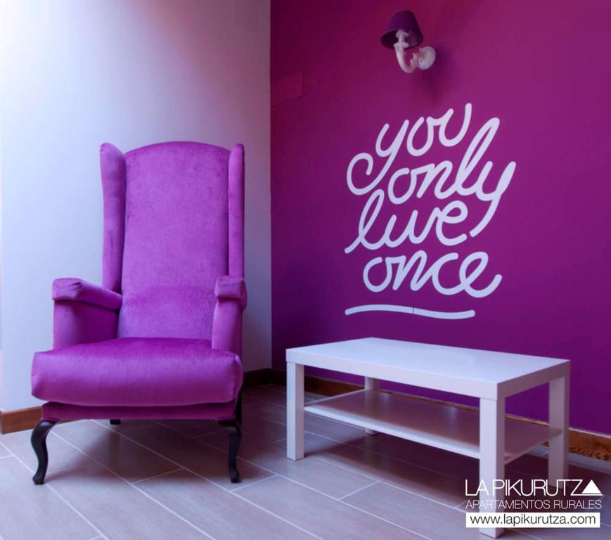 a purple chair and a table in a room at Apartamentos Rurales La Pikurutza in Bernedo