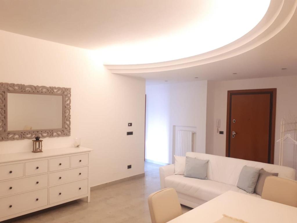 a living room with a white couch and a dresser at Dimora Brezza di Mare in Termoli