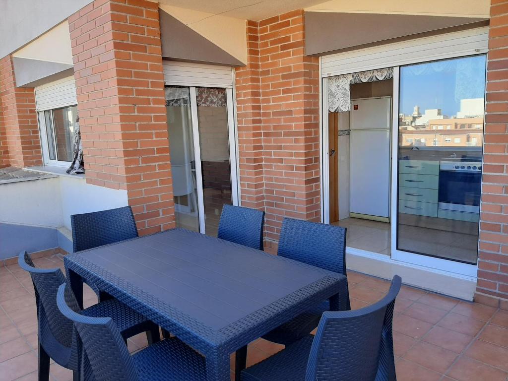 une table bleue et des chaises sur une terrasse dans l'établissement Àtic RENDILLA, à Sant Carles de la Ràpita