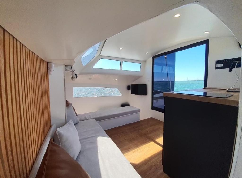 uma pequena sala de estar com um sofá e uma mesa em Barco Casa Catamarã Sleepandboat em Faro