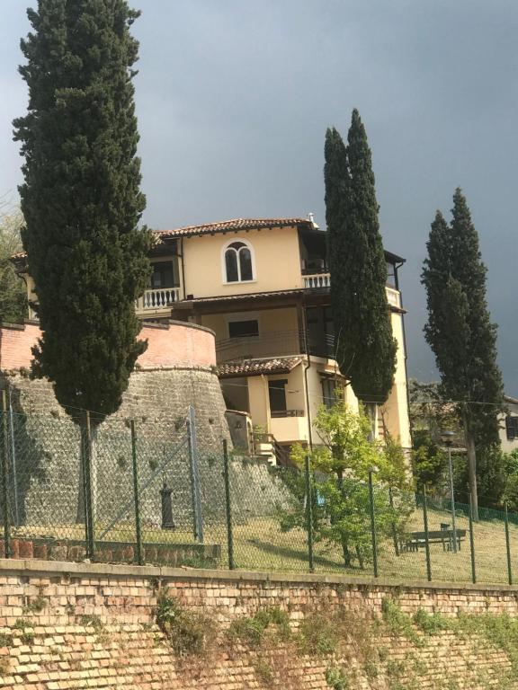 una casa detrás de una valla con árboles delante de ella en Il Ritrovo de La Pre, en Predappio