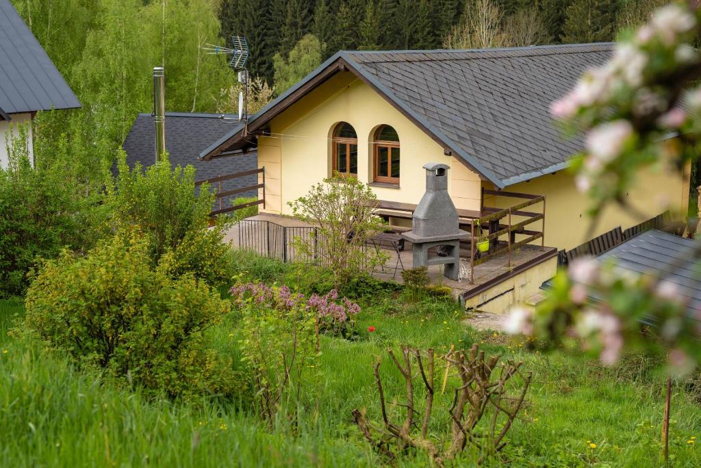 ein kleines gelbes Haus mit schwarzem Dach in der Unterkunft Chata Pohoda in Rokytnice nad Jizerou