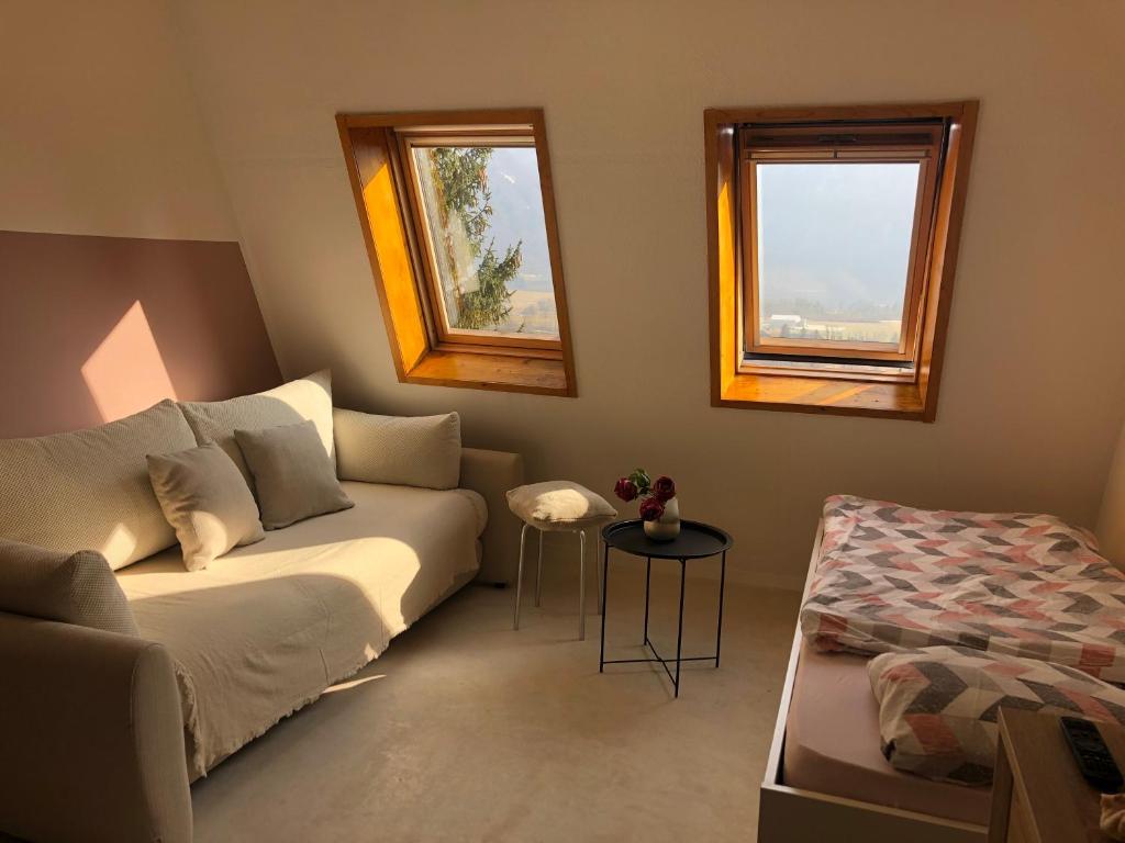 un soggiorno con divano e 2 finestre di Bovec Apartment a Bovec