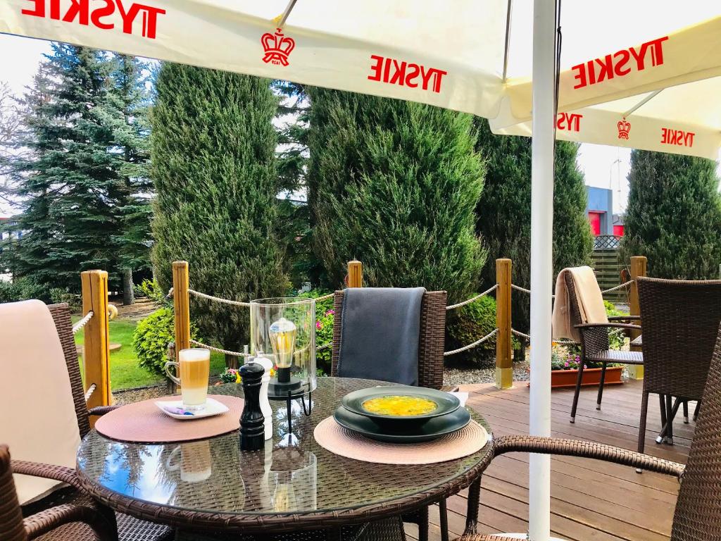 a table on a patio with an umbrella at Restauracja 32 Motel in Gryfice