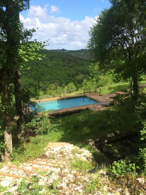 une piscine au milieu d'un champ avec des arbres dans l'établissement Natuur en stilte in een bijzondere omgeving, à Thézac
