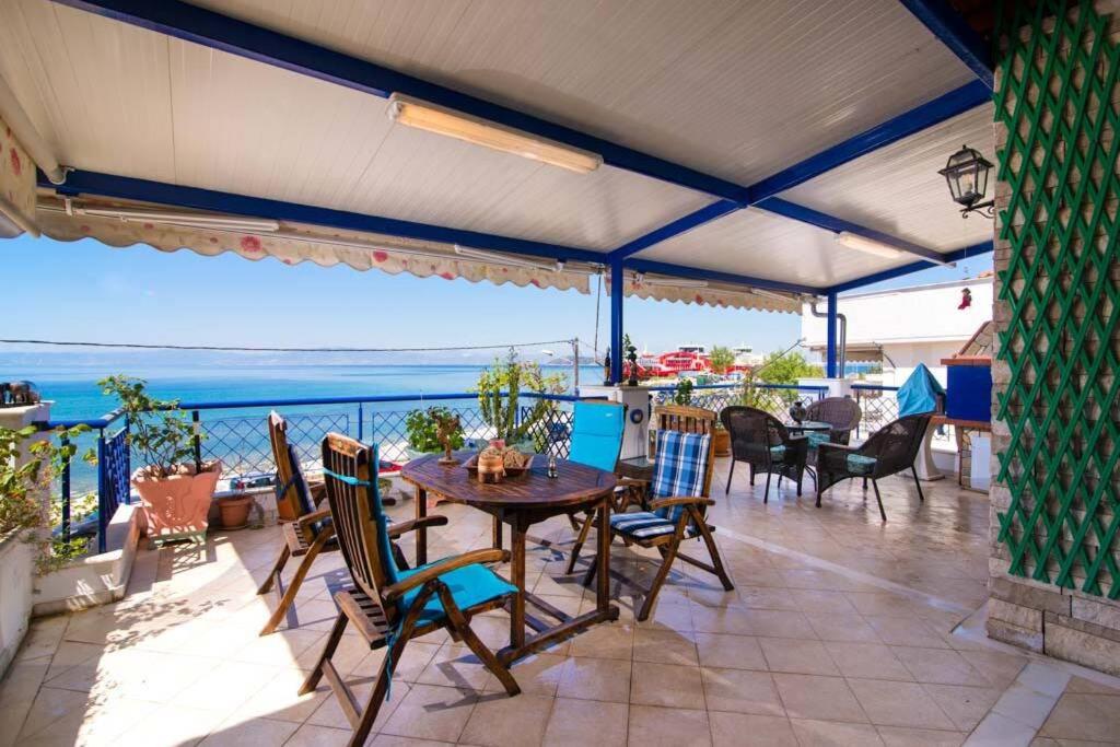 a patio with a table and chairs and a view of the ocean at Villa Porto Thassos in Limenas