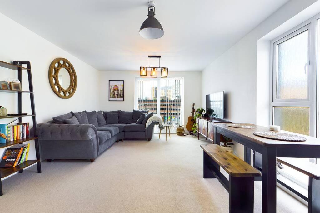 a living room with a couch and a table at Chic City Centre Apartment With Allocated Parking in Swansea