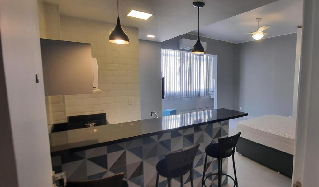 a kitchen with a counter with chairs and a bed at Charme da Bolivar in Rio de Janeiro