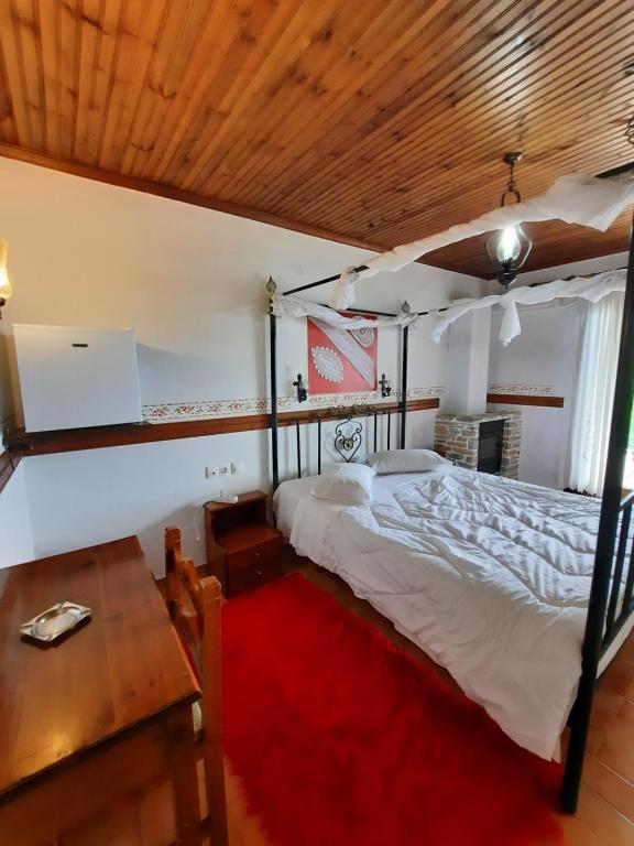 ein Schlafzimmer mit einem Bett und einer Holzdecke in der Unterkunft Αρχοντικό Κονάκι- Konaki Pelion in Tsagkarada