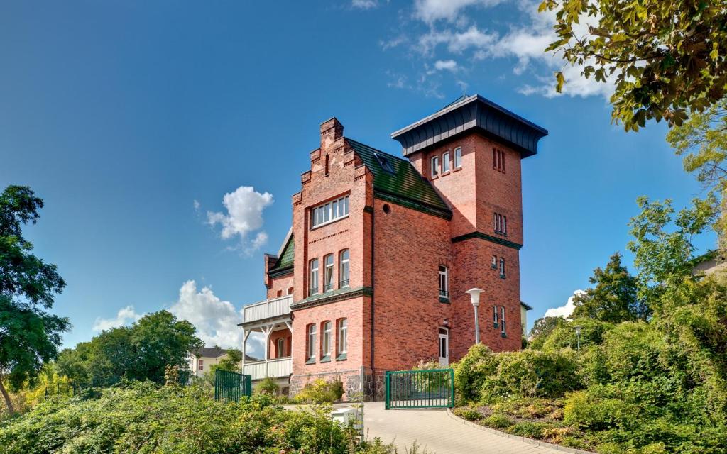 ザスニッツにあるHistorische Seelotsenstation Sassnitzの高台の塔のある古いレンガ造りの建物