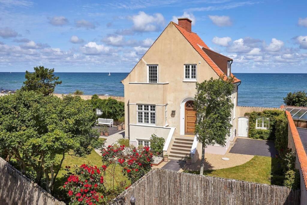a house with the ocean in the background at Exceptionel Beach House at the Ocean in Gilleleje