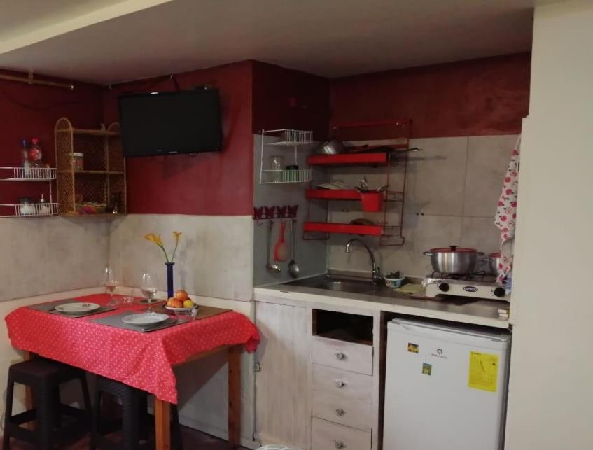 una pequeña cocina con paredes rojas y encimera. en Mini suites en el mejor sector de la ciudad, en Quito