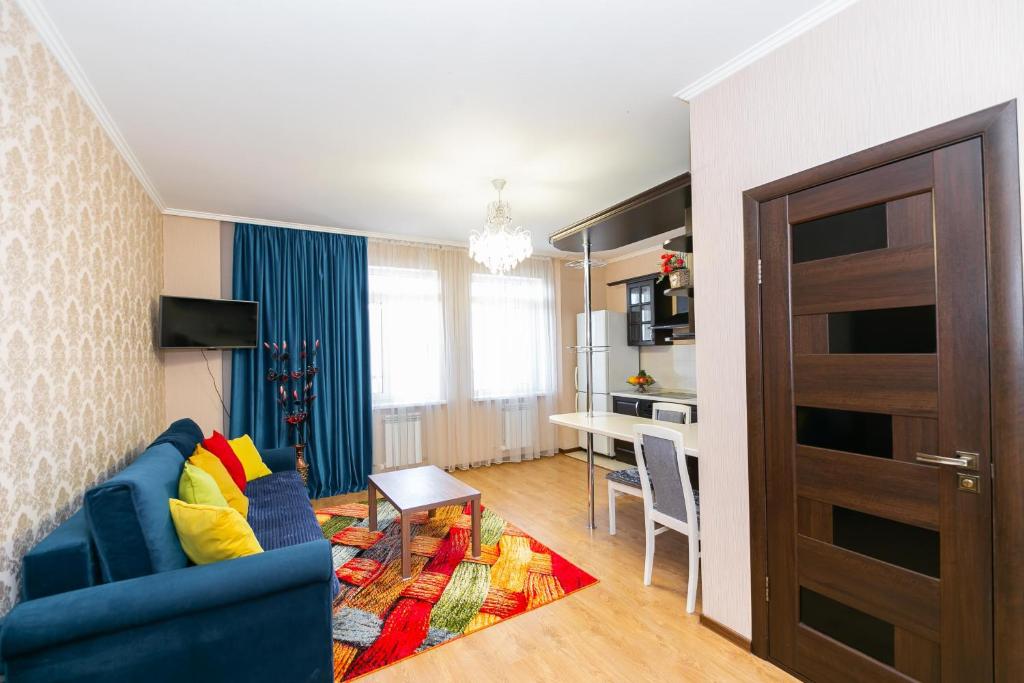 sala de estar con sofá azul y cocina en В Promenade Expo квартира с романтическим видом en Astaná