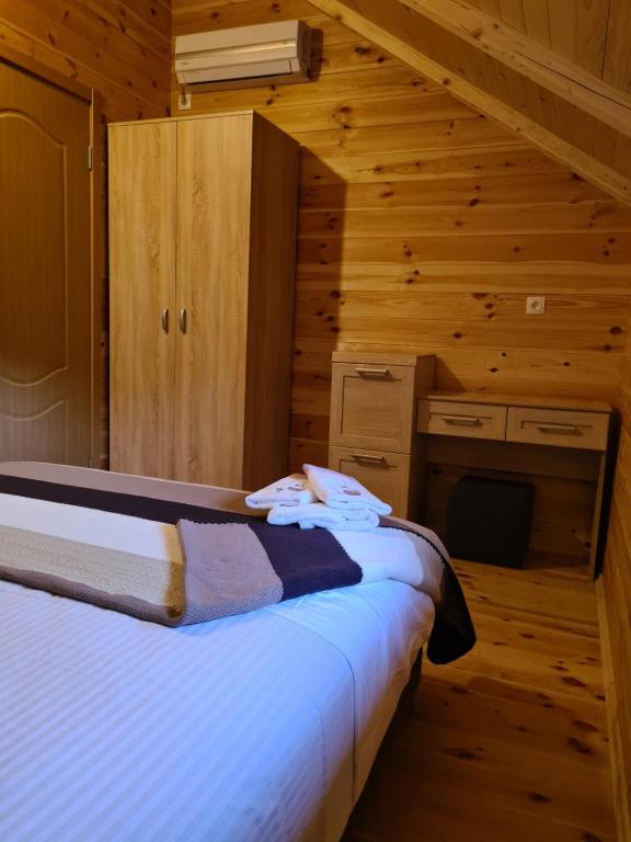 a bedroom with a bed in a log cabin at OLEA COTTAGE in Ulcinj
