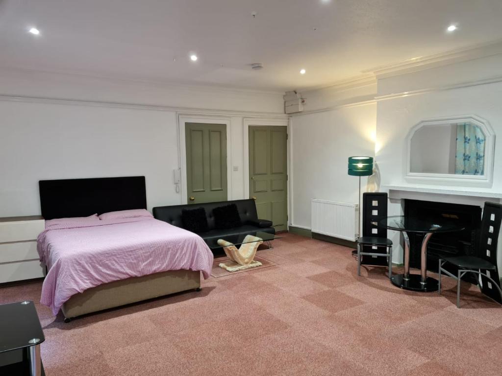 - une chambre avec un lit, un canapé et une cheminée dans l'établissement County Studio, à Ipswich