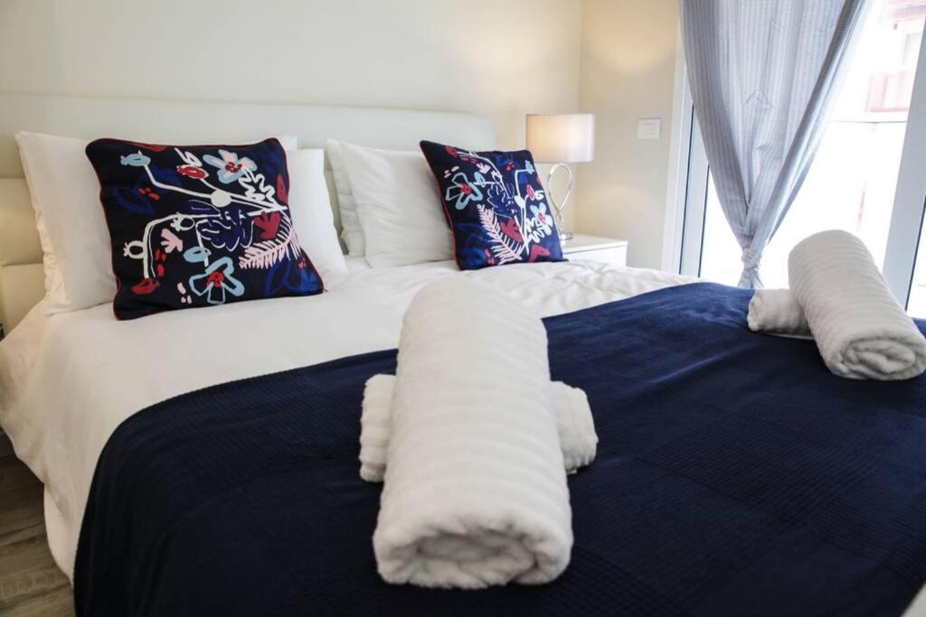 ein Schlafzimmer mit einem blauen und weißen Bett mit Kissen in der Unterkunft Magnifique 3P - French riviera - 3mn beach - Air Conditioning - Balcony in Juan-les-Pins