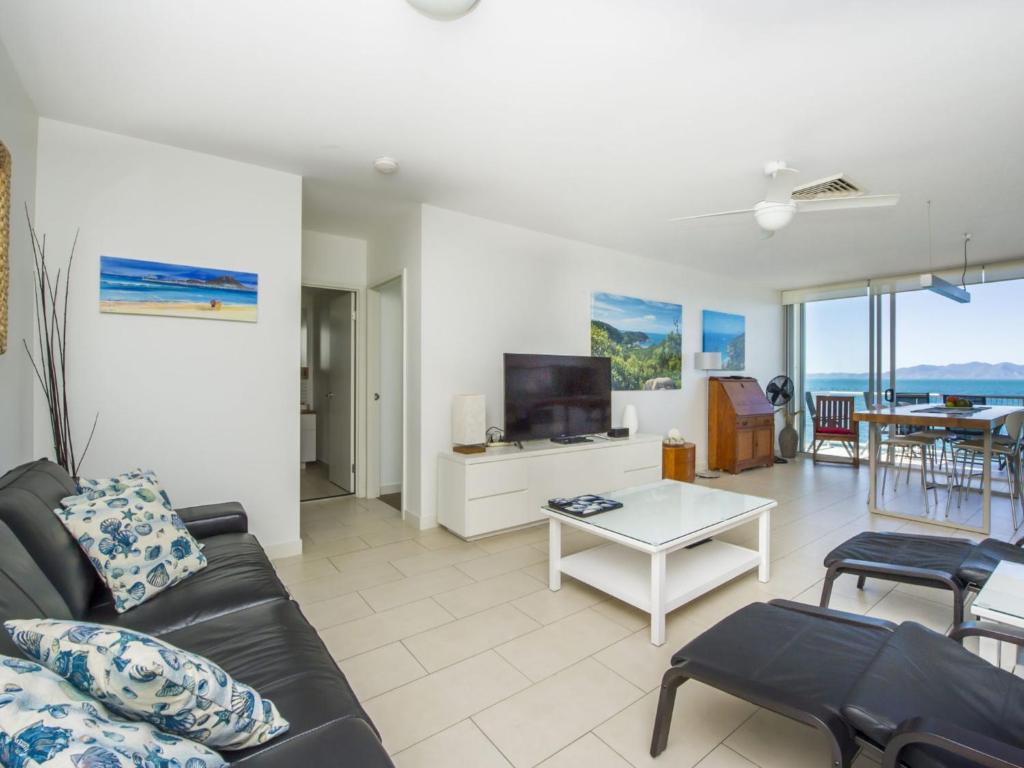 a living room with a couch and a table at 1 Bright Point Apartment 5102 in Nelly Bay