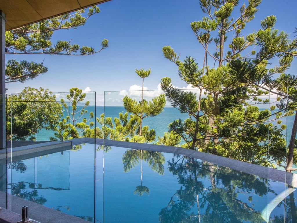 a view of the ocean from a house with a swimming pool at Headland House in Picnic Bay