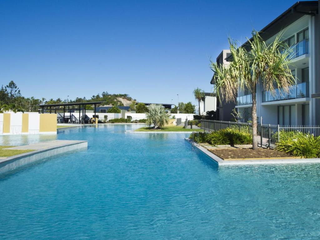 a swimming pool in front of a building at Blue on Blue Apartment 921 in Nelly Bay