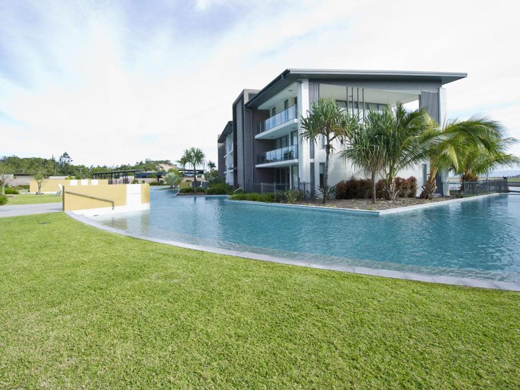 a swimming pool in front of a building at Blue on Blue Apartment 812 in Nelly Bay