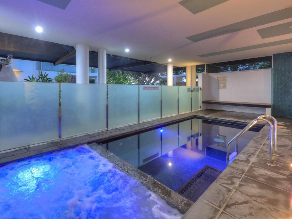 a swimming pool with blue lights in a building at Maggies Beachfront Apartment 11 in Horseshoe Bay