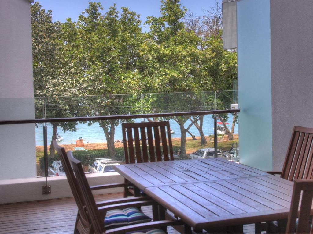 a table and chairs on a balcony with a view of the ocean at Maggies Beachfront Apartment 6 in Horseshoe Bay