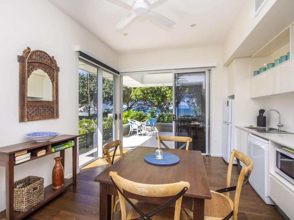 Picnic Bay的住宿－Reflections Turquoise Villa 4，厨房以及带桌椅的用餐室。