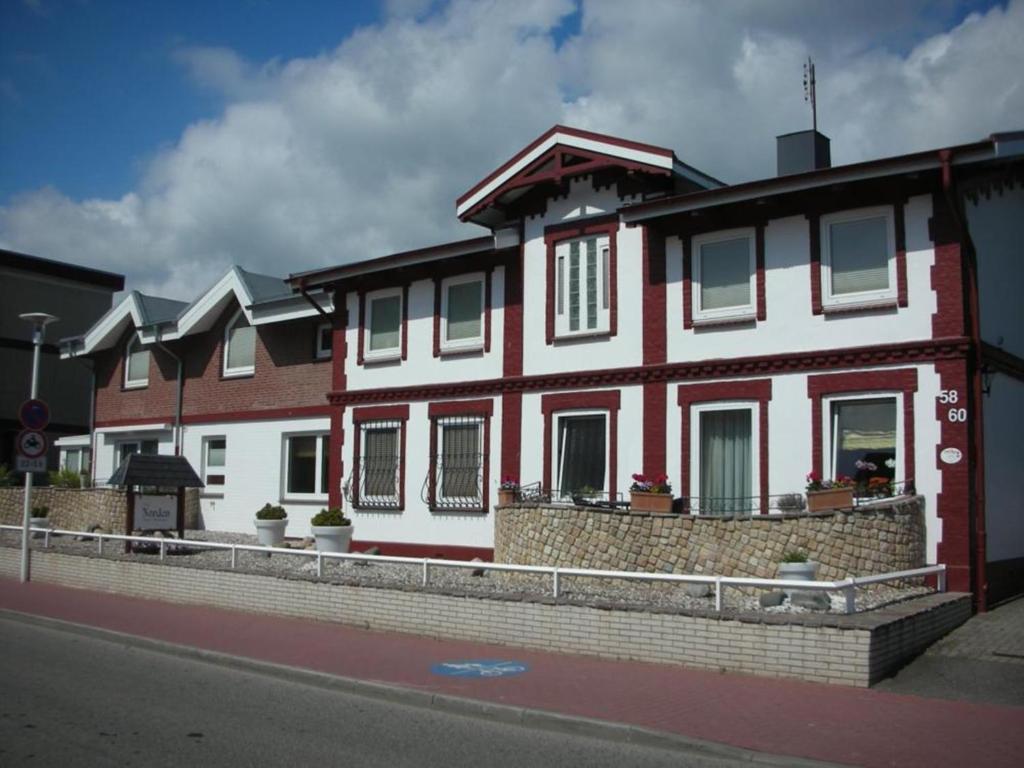a red and white house on the side of a street at Haus Norden in Grömitz