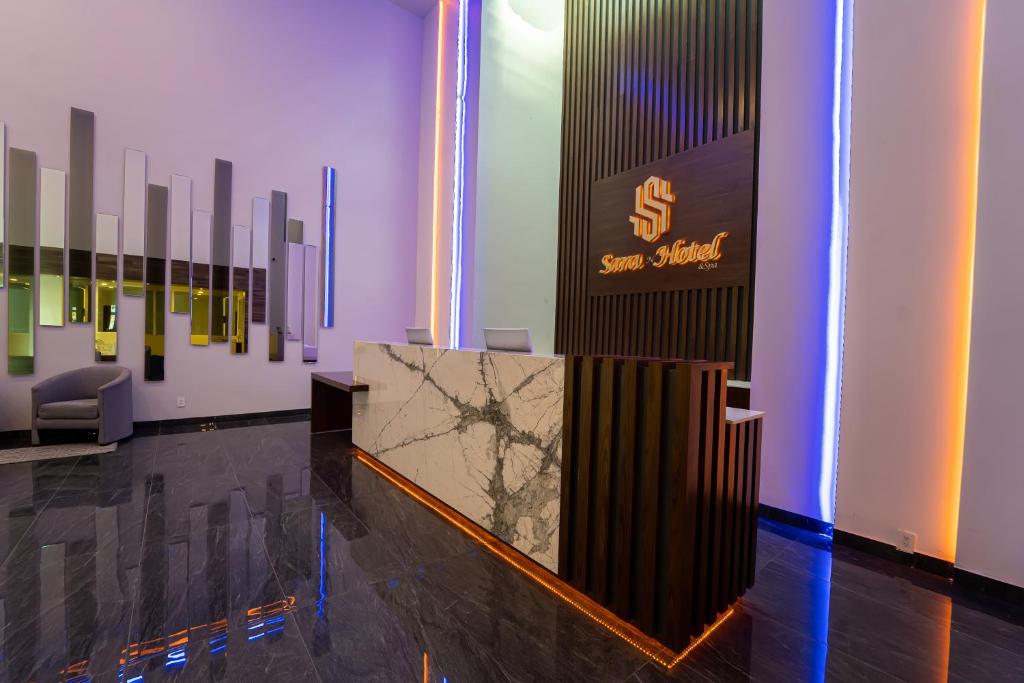 um lobby com um balcão e um sinal na parede em Sara N Hotel & Spa em Zapotlanejo