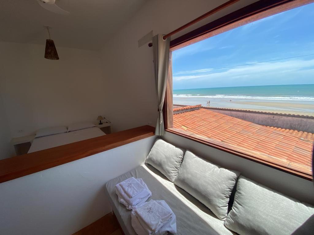 a room with a couch and a window with a view of the beach at Navegantes Nascente in Guajiru
