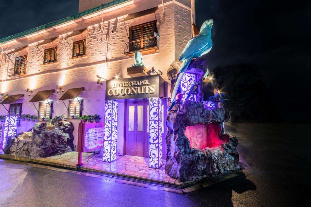 un edificio iluminado con una estatua delante de él en リトル チャペル ココナッツ 天王寺, en Osaka