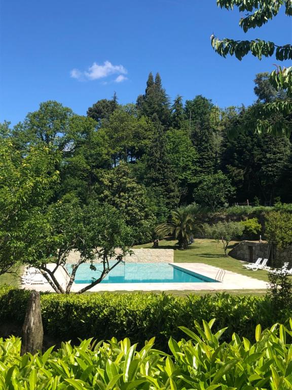 una piscina en un jardín con árboles en Quinta de Barbêdo, en Caniçada