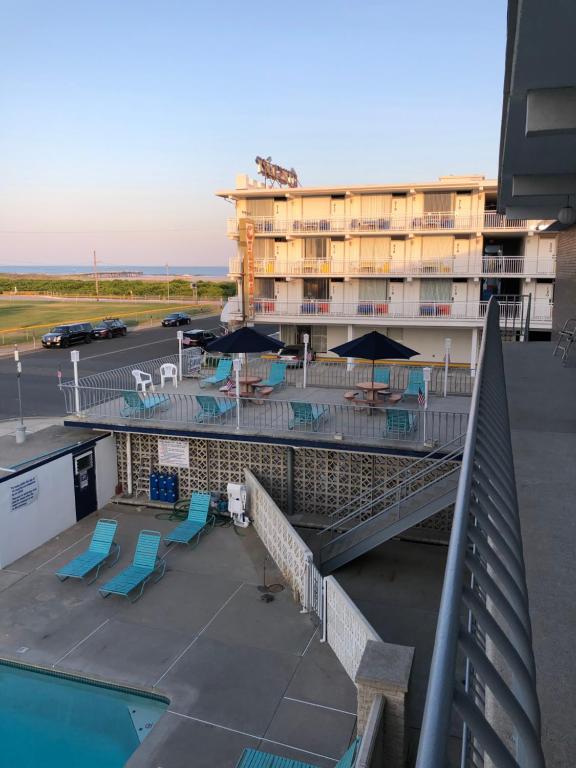 a hotel with a pool and chairs and umbrellas at Yankee Clipper Resort Motel in Wildwood Crest