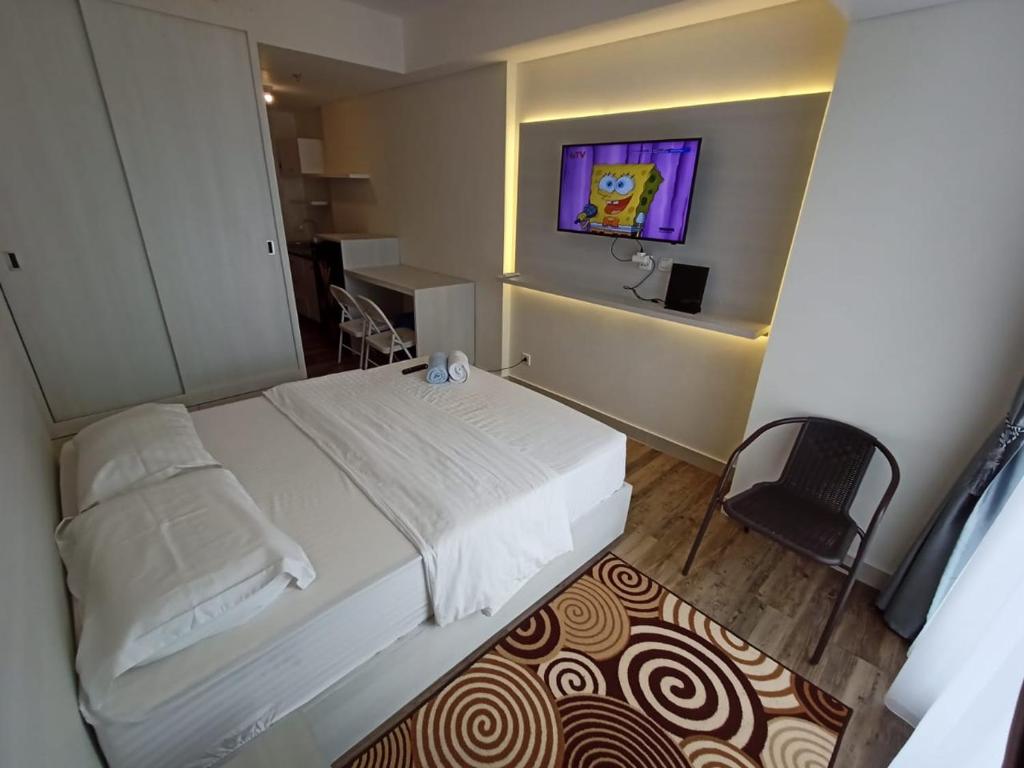 - une chambre avec un grand lit blanc et une fenêtre dans l'établissement SleepRest @ Pollux Habibie, à Batam Center