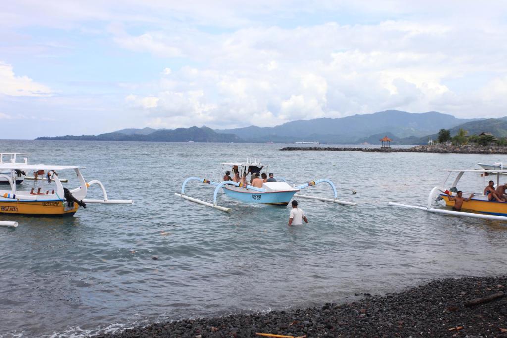 un grupo de personas en el agua en barcos en Ashyana Candidasa Beach Resort, en Candidasa