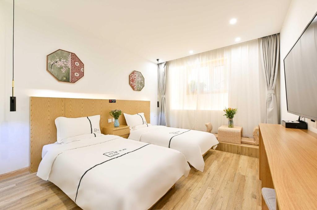 Postel nebo postele na pokoji v ubytování Xingshe Alley Courtyard Hotel Beijing Wangfujing Forbidden City Branch - Breakfast included & English speaking reception & Free WiFi and Laundry room & Hutong Culture & Cat-keeping & Flower-growing Terrace & One day tour service & Free coffee