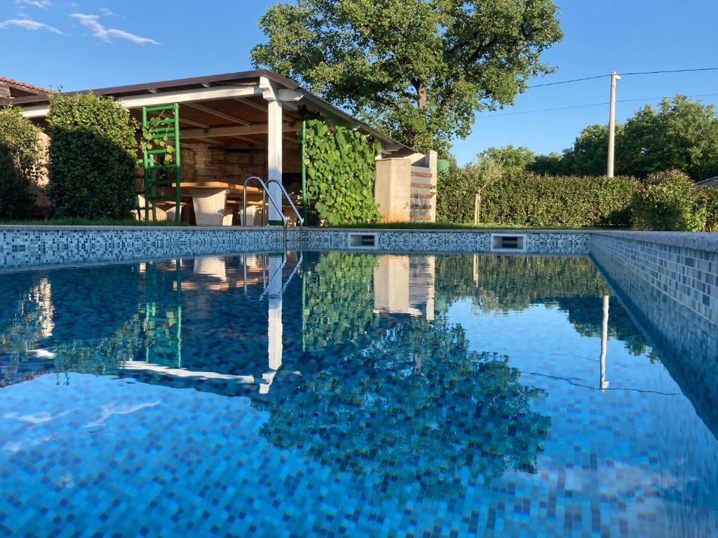 a swimming pool with blue water in front of a house at La Casa de Papel in Buje