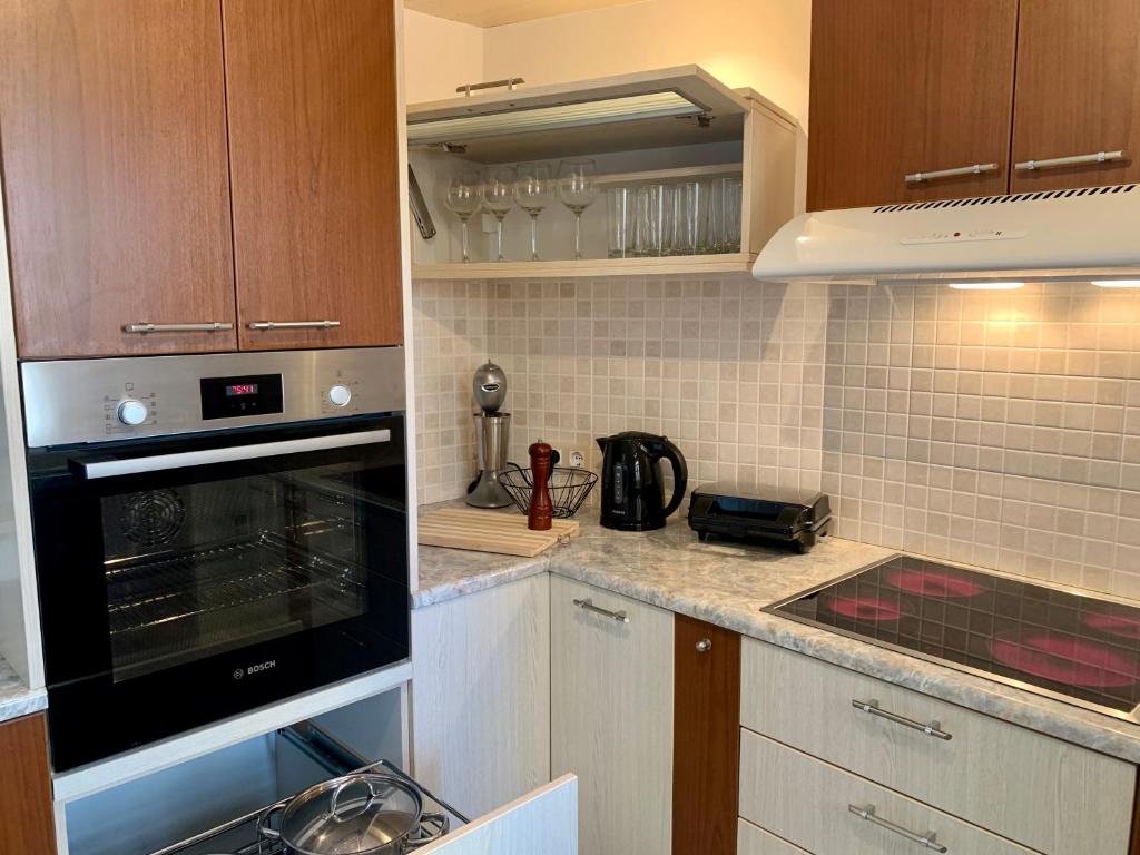 a kitchen with wooden cabinets and a stove top oven at PORTA HOME modern and hospitable in Naxos Chora