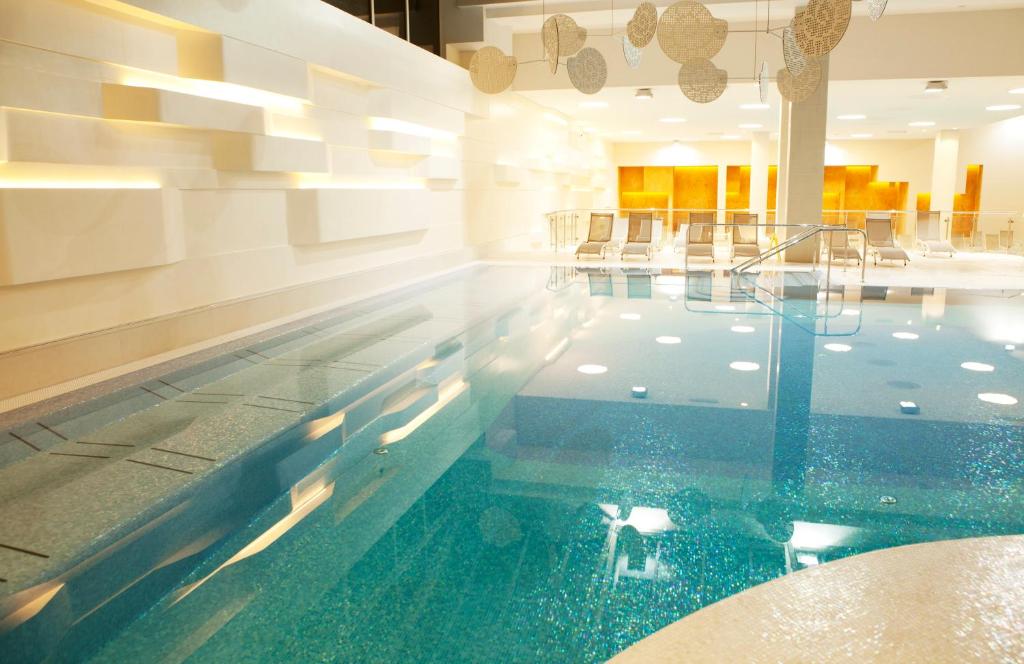 a swimming pool with blue water in a building at Hotel Neptun - Terme & Wellness Lifeclass in Portorož