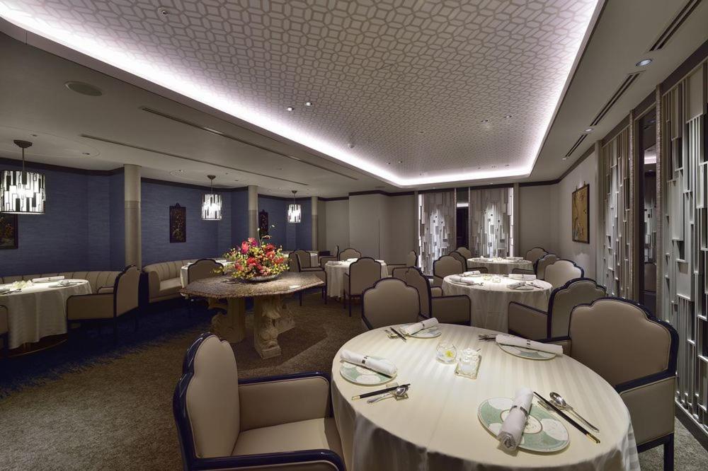 a dining room with tables and chairs in a restaurant at Hotel Nikko Fukuoka in Fukuoka