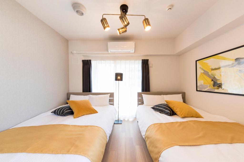 福岡市にあるSG RESIDENCE INN HAKATAの窓のある部屋にツインベッドが2台