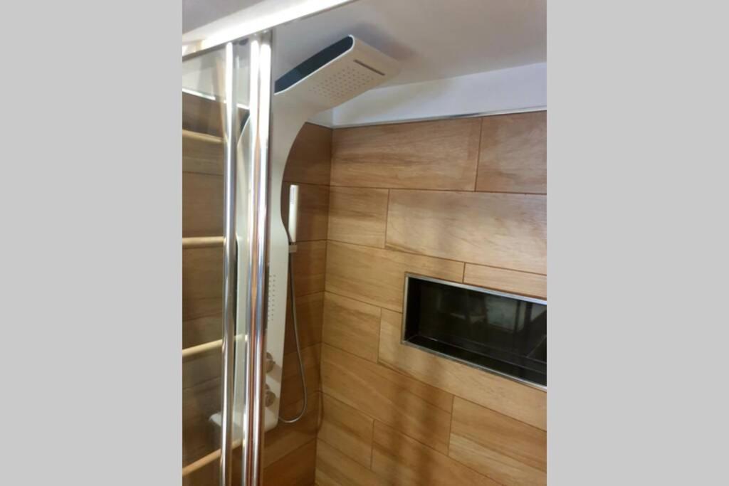 ein Bad mit einer Dusche und einem TV in der Unterkunft Casa dos pelicanos 3 ROOMS in Sesimbra