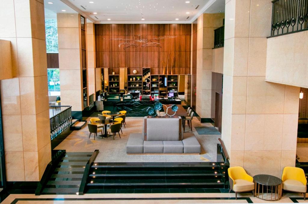 a lobby of a hotel with tables and chairs at Perdana Kuala Lumpur City Centre in Kuala Lumpur