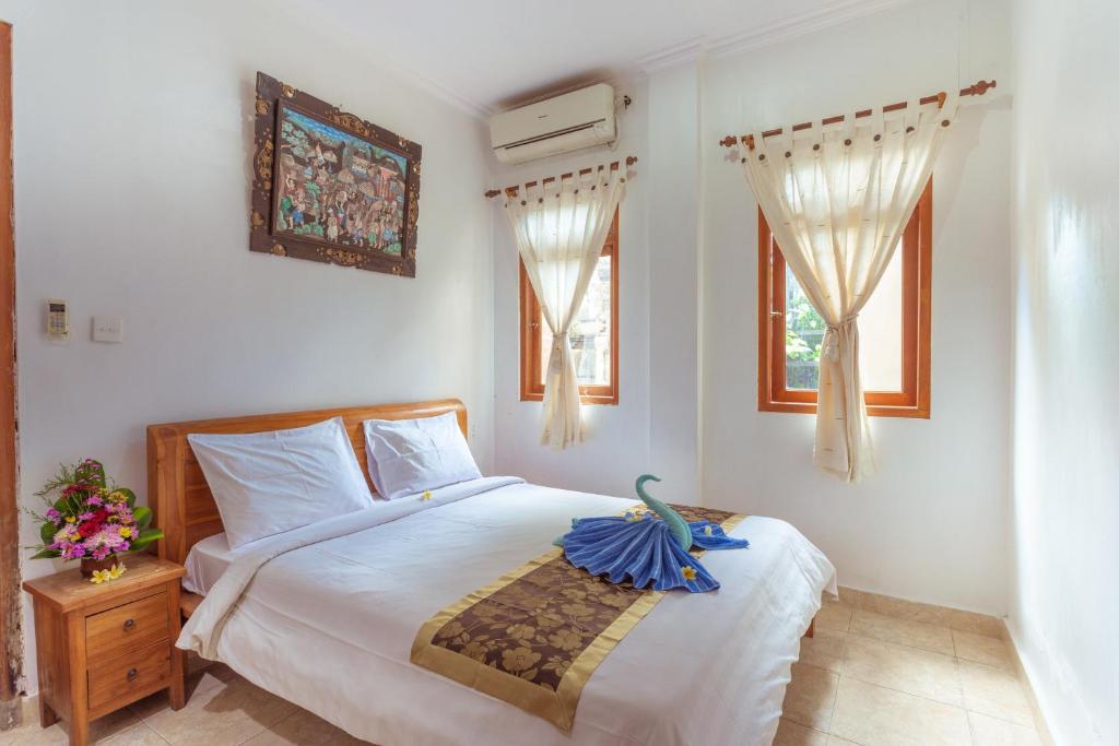 una camera da letto con un letto e un uccello seduto sopra di Teba House Ubud by ecommerceloka - CHSE Certified ad Ubud