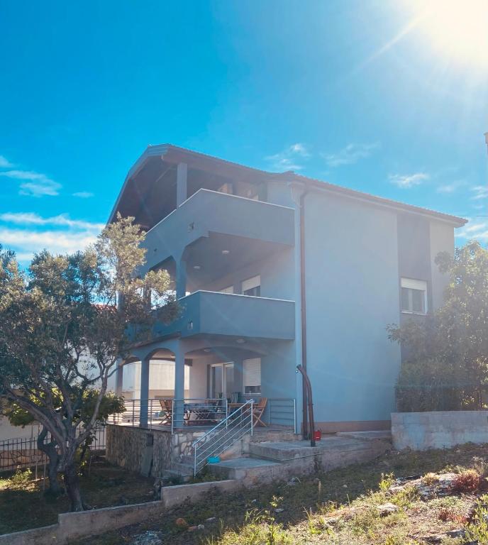a white building with a staircase on the side of it at Lili Murter in Murter