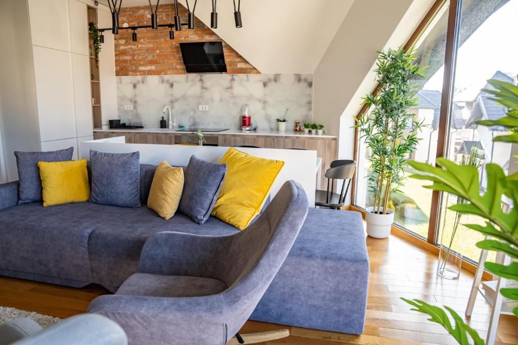 uma sala de estar com um sofá azul e almofadas amarelas em Sunny Sight Zlatibor em Zlatibor