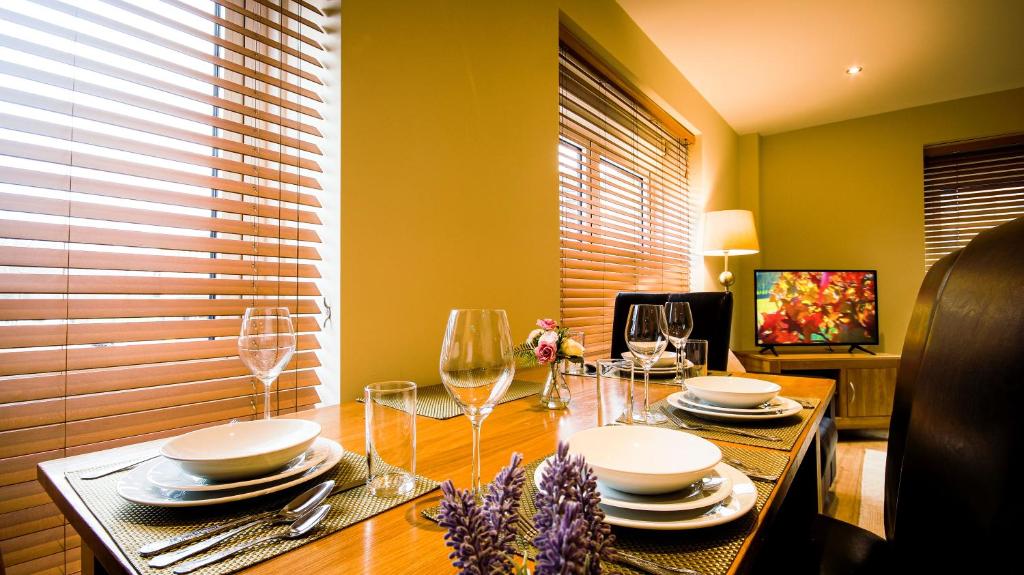 a dining room table with plates and wine glasses at Superb City Center 1 or 2 BR Apts King Bed - Wise Stays in Southampton