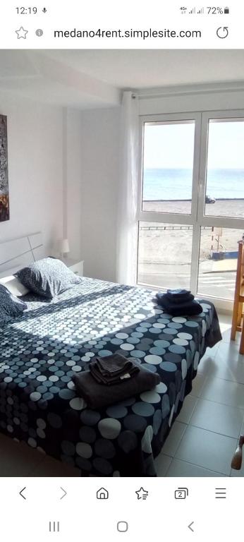 - une chambre avec un lit et une vue sur l'océan dans l'établissement Un dormitorio frente playa El Medano, à El Médano