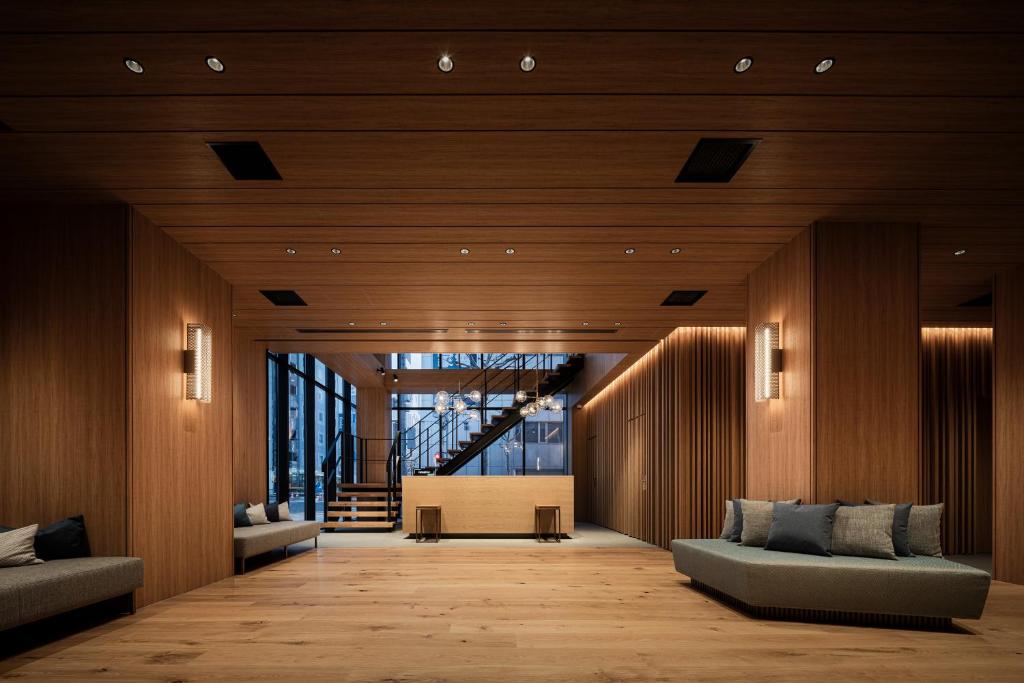 a living room with two couches and a staircase at Bespoke Hotel Sapporo in Sapporo